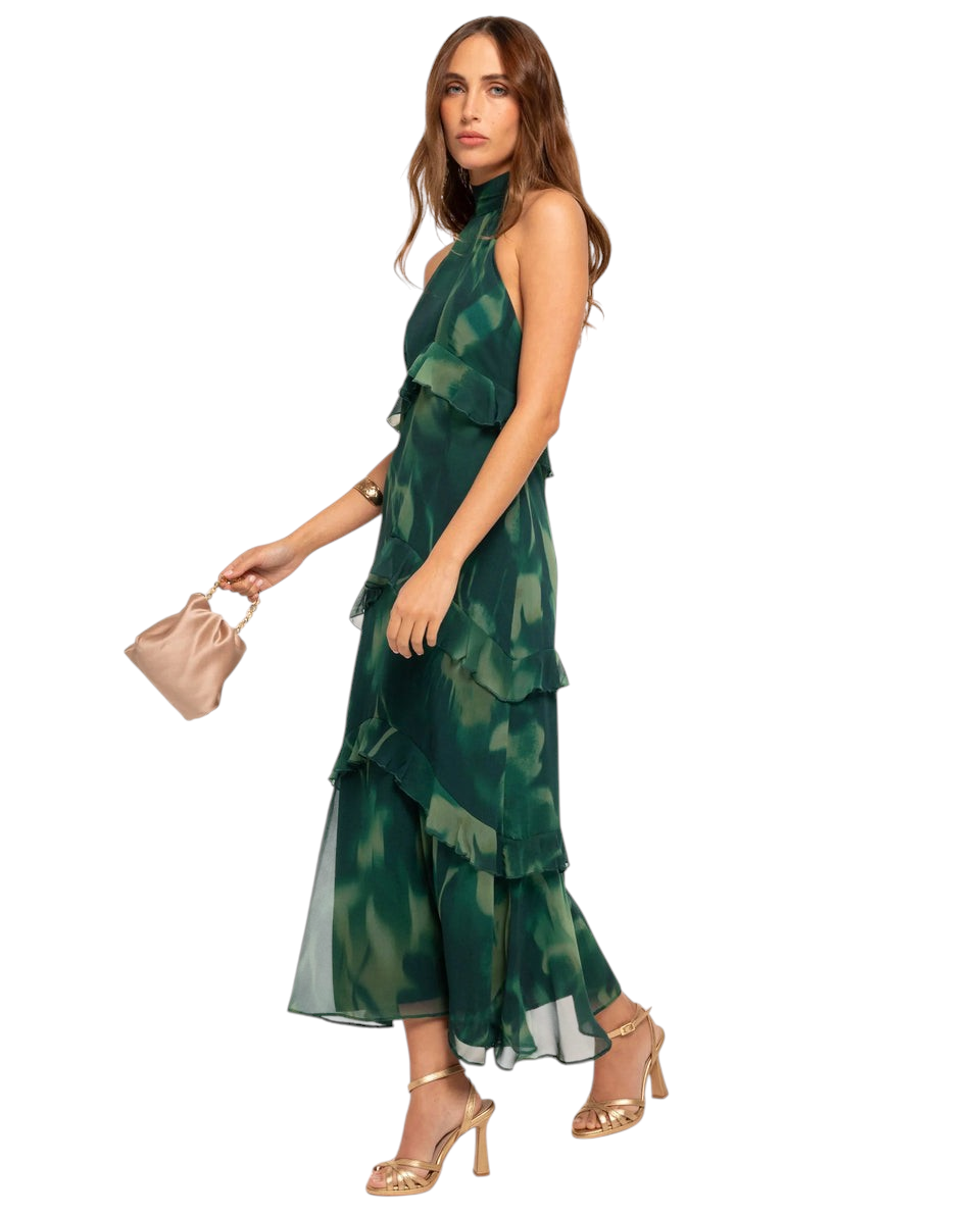 Modelo con vestido midi Mara Domínguez Esme verde con estampado, cuello halter y detalles de volantes en capas.