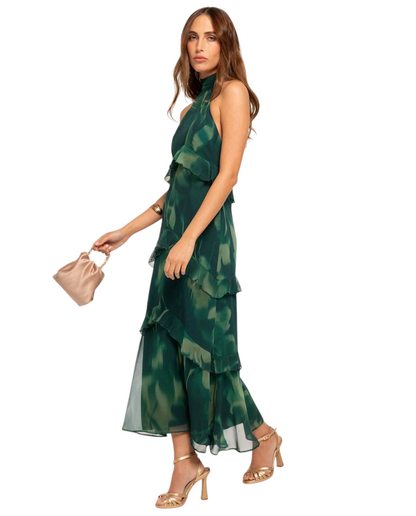 Modelo con vestido midi Mara Domínguez Esme verde con estampado, cuello halter y detalles de volantes en capas.