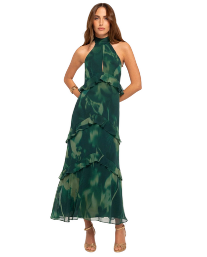 Modelo luciendo vestido largo Mara Domínguez Esme en verde con estampado abstracto, cuello halter y volantes