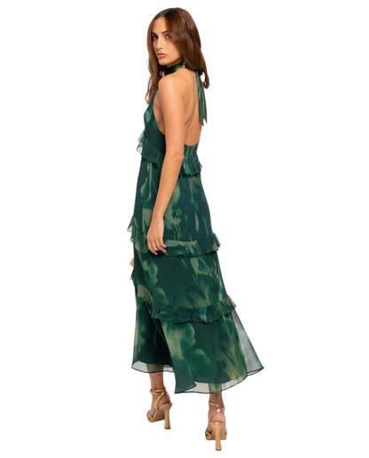 Modelo posando con vestido midi Mara Domínguez Esme verde con estampado floral, cuello halter y detalles de volantes