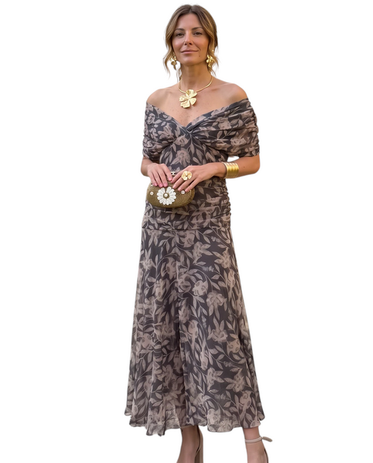 Mujer con vestido midi Mara Domínguez estampado floral gris con escote barco en un jardín elegante