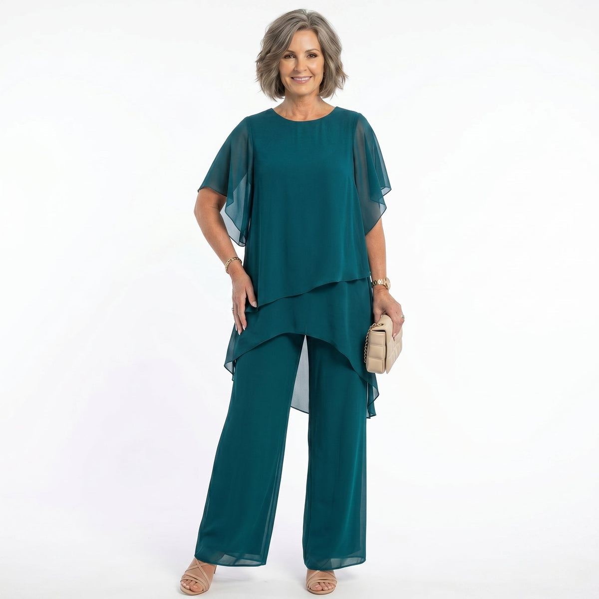 Mujer madura vistiendo el conjunto elegante Ainhoa de Mara Domínguez en color verde esmeralda con blusa de capas