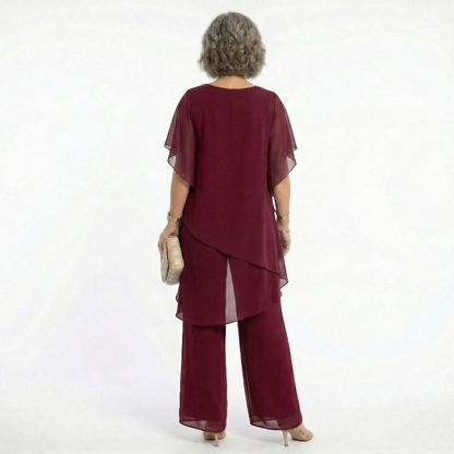 Vista trasera del conjunto Mara Domínguez Ainhoa en color burdeos con blusa de capas asimétricas y pantalón fluido