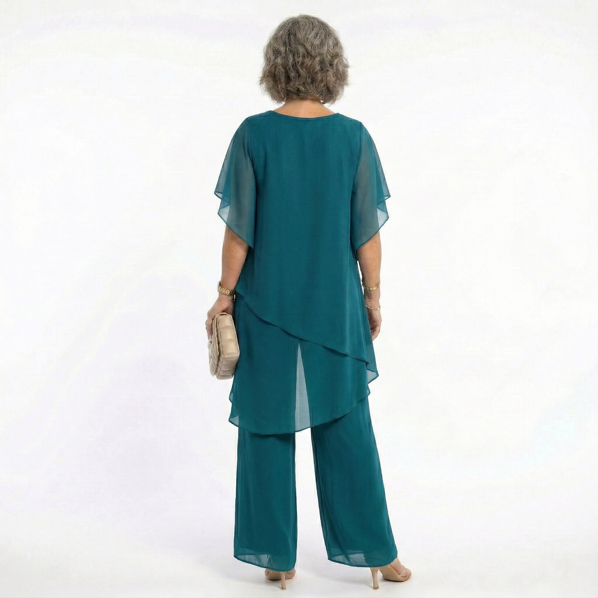 Vista trasera del conjunto Mara Domínguez Ainhoa en verde azulado con blusa de capas y pantalón fluido para eventos.