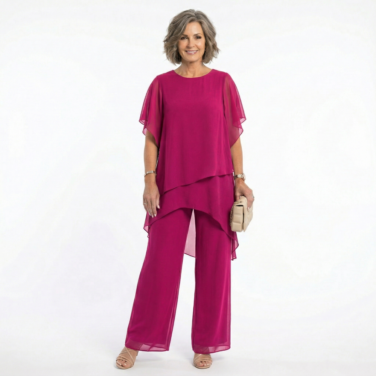 Mujer madura vistiendo conjunto Mara Domínguez de dos piezas color fucsia con blusa de capas y pantalón fluido