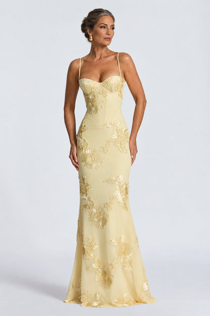 Vestido largo Mara Domínguez color amarillo pastel con escote corsé, tirantes finos y bordados florales en relieve.