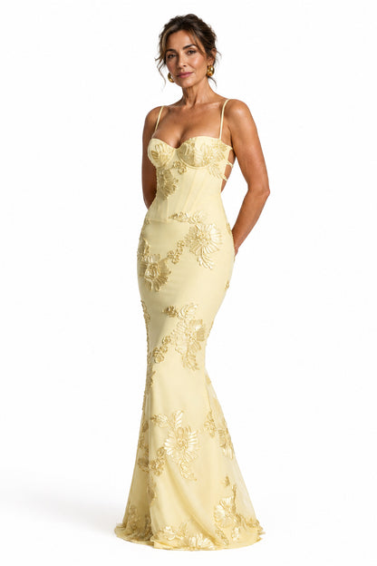Modelo luciendo vestido largo Mara Domínguez color amarillo pastel con escote corsé y bordados florales en relieve