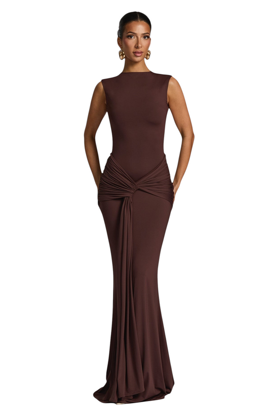 Modelo luciendo el vestido largo Mara Domínguez Daria en color marrón chocolate con drapeado elegante en la cintura.