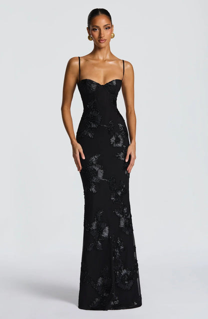 Modelo luciendo vestido largo negro Mara Domínguez con escote corsé, tirantes finos y bordados florales en relieve