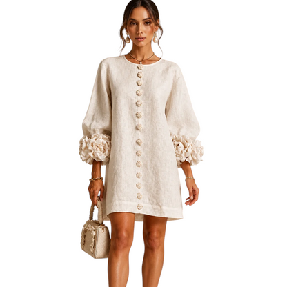 Modelo vistiendo vestido corto de lino beige Mara Domínguez con mangas abullonadas y detalles florales en los puños