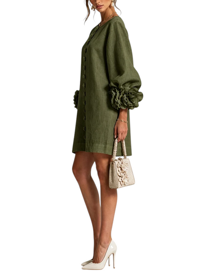 Vestido corto de lino verde Mara Domínguez con mangas abullonadas, detalles florales en puños y botones frontales.
